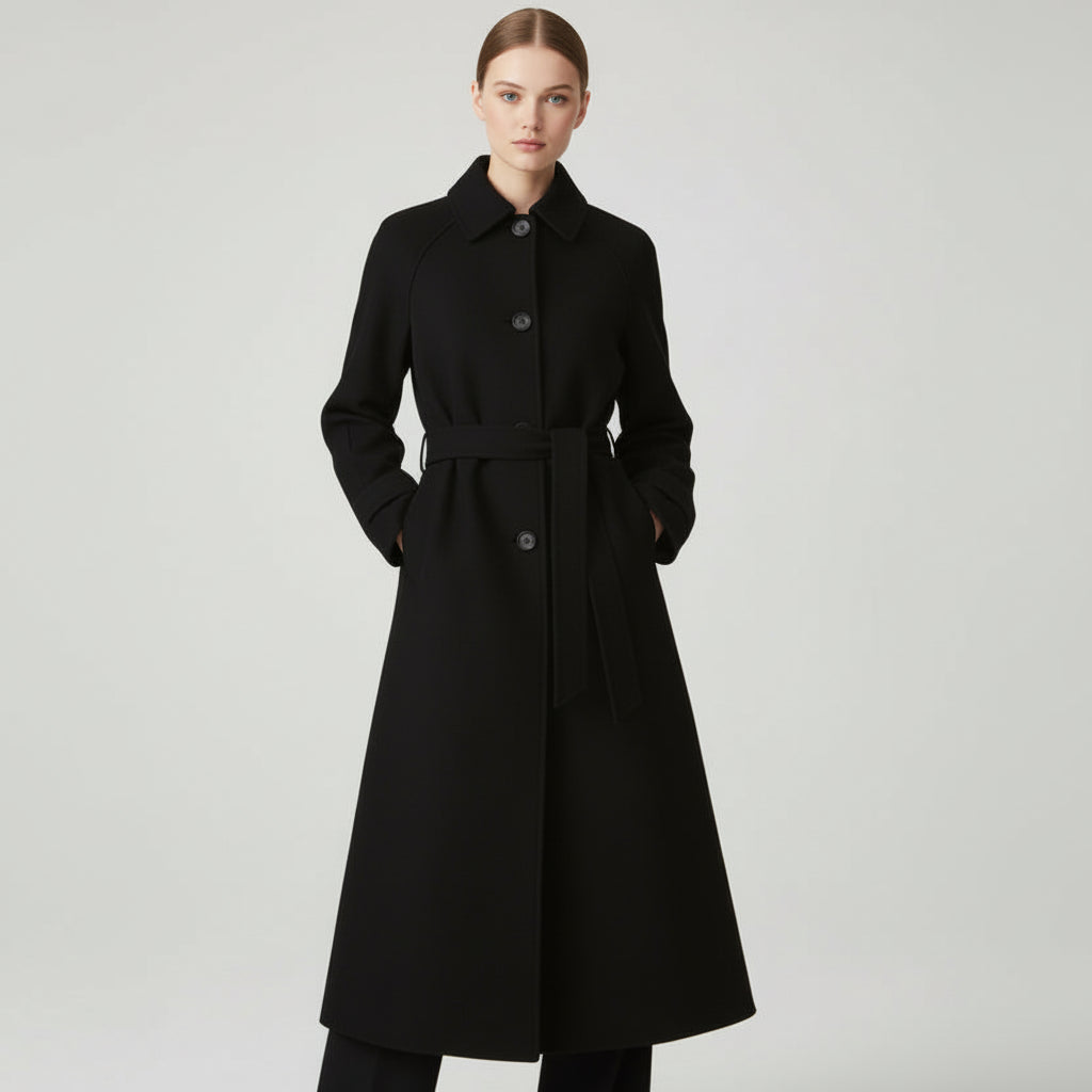 Woman wearing a black coat on a light gray background